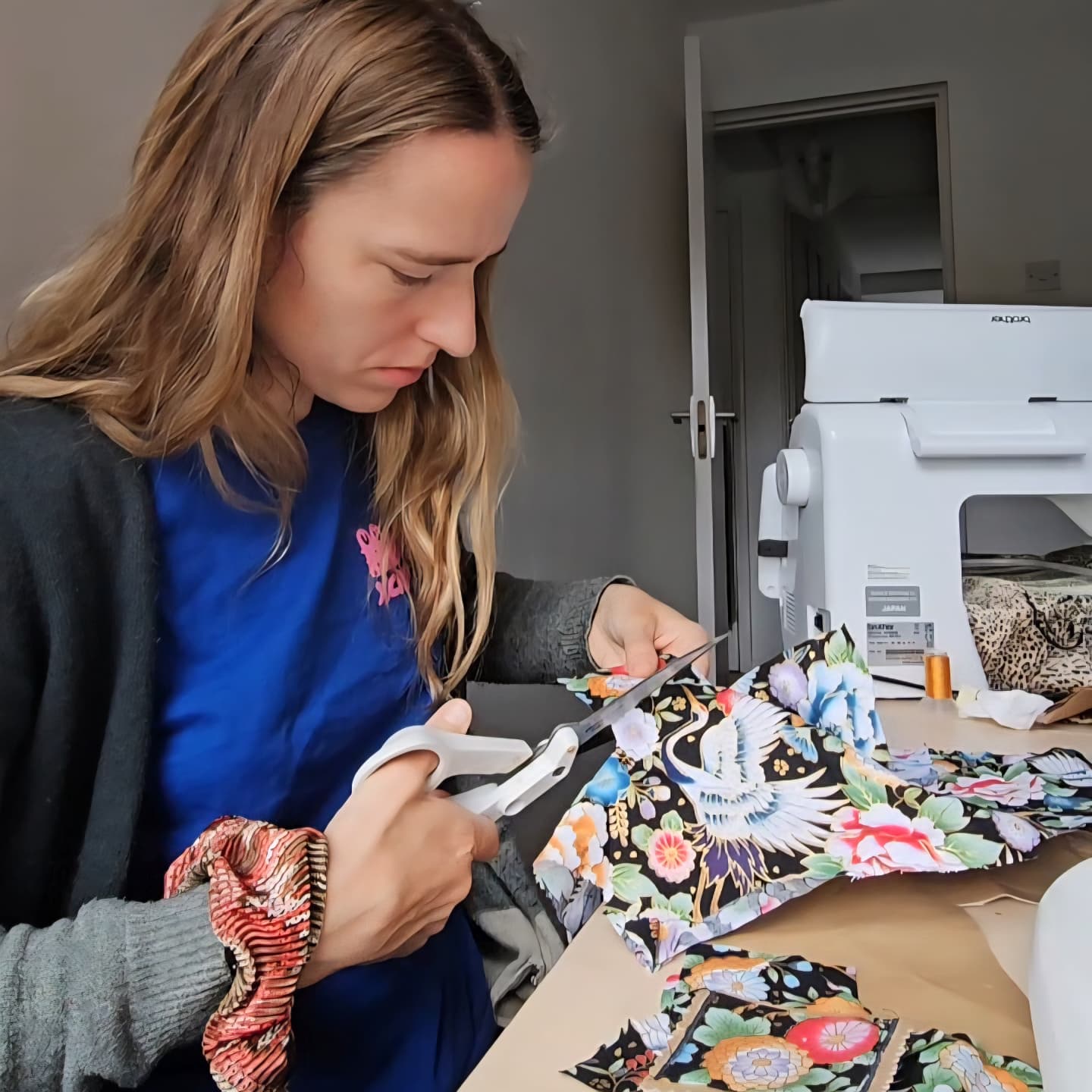 Woman cutting fabric with scissors in a sewing room